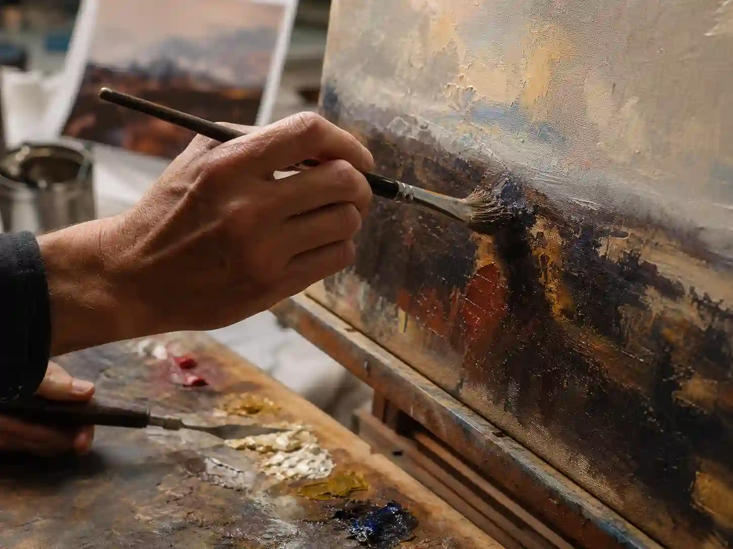Close-up of a DafenArts master artist hand-painting a custom landscape oil painting on canvas, showcasing authentic brushwork with the hand carefully elevated above the wet oil paint to ensure technical precision.