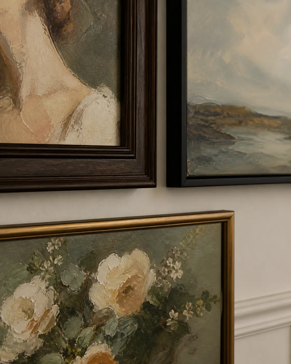 close view of mixed wood black and warm gold frames around oil paintings